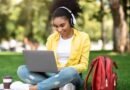 African Student Girl Learning On Laptop Wearing Earphones In Park
